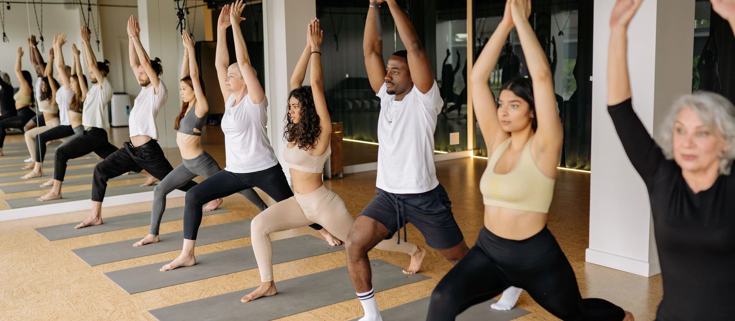 A group of people doing yoga and working out together at sunset in a park